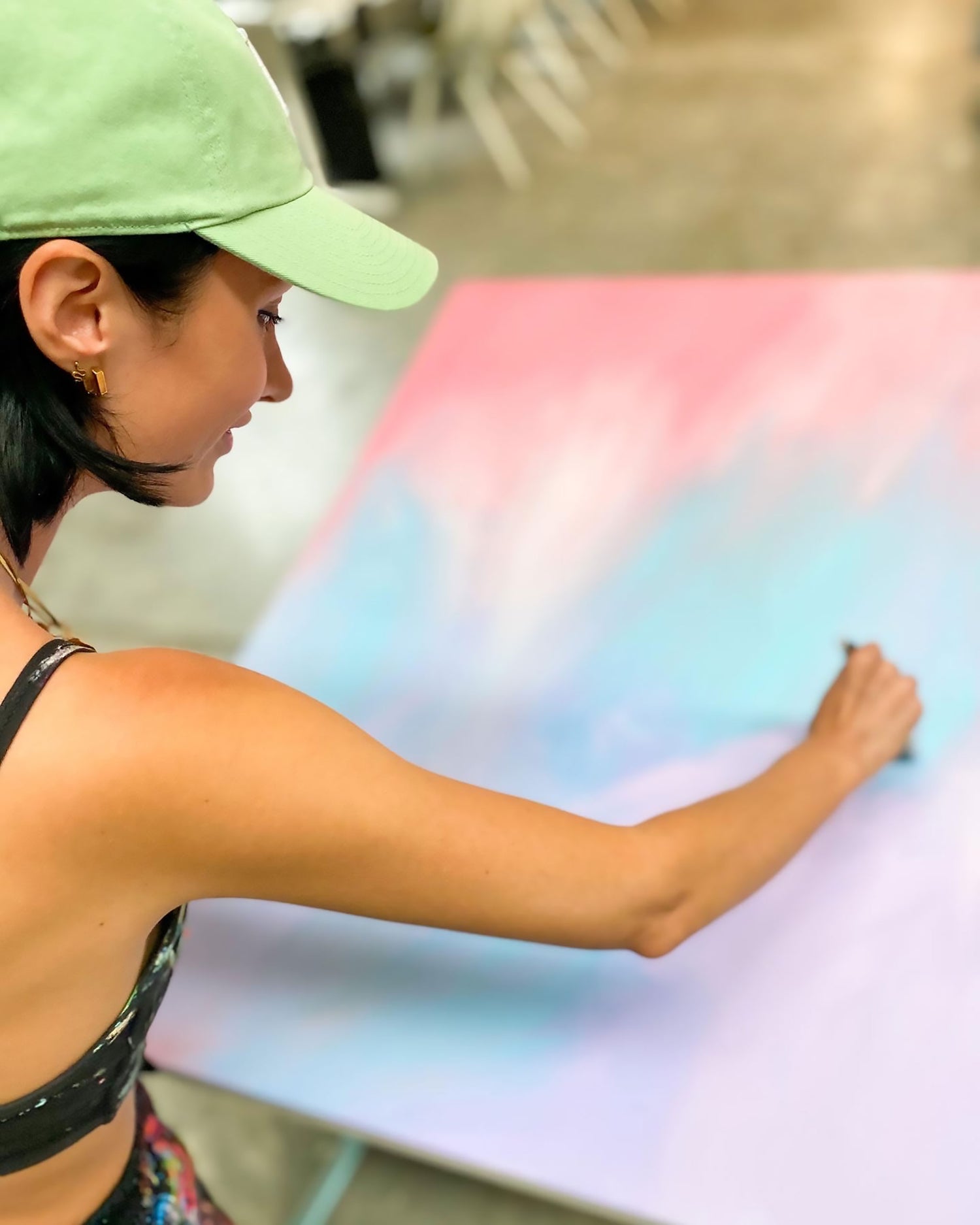 Bridget Bradley, Abstract Expressionism Artist, wearing green cap and seen painting a new abstract on canvas.
