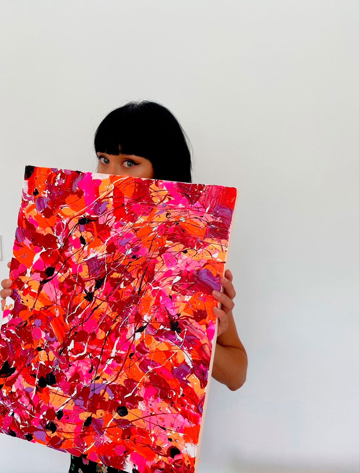 Bridget Bradley, holding her original abstract expressionism painting