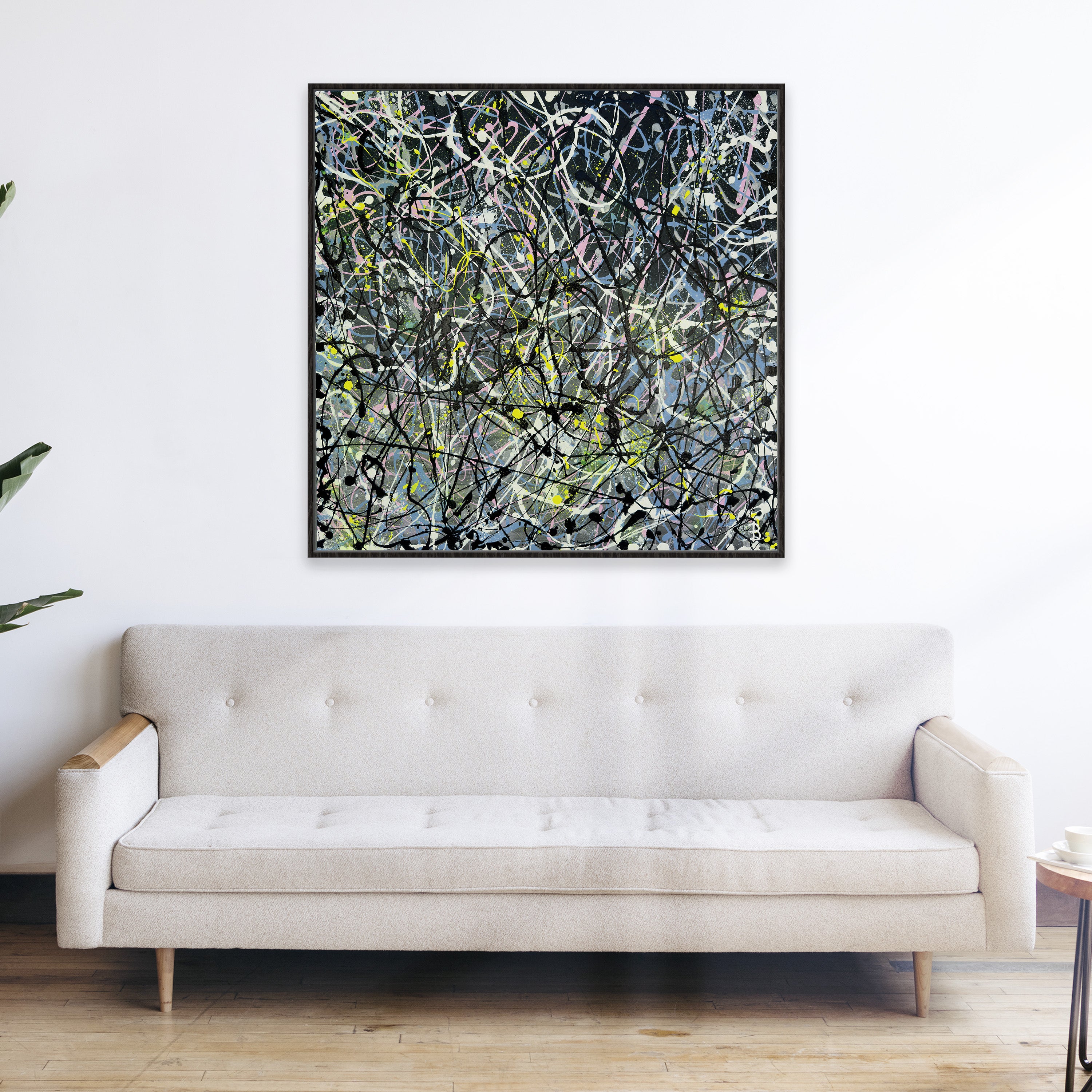 Abstract Fine Art print framed in black float frame hanging above sofa on white wall. After the original artwork by Bridget Bradley
