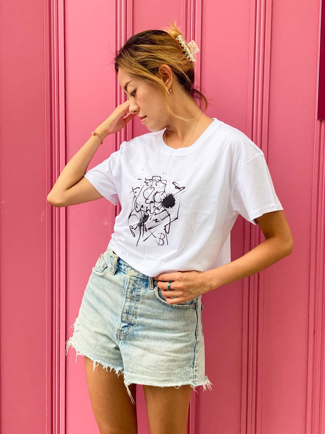 Model Stands against Pink Background Wearing The Eva Crop Top Tee. B Contemporary Streetwear designed by Bridget Bradley