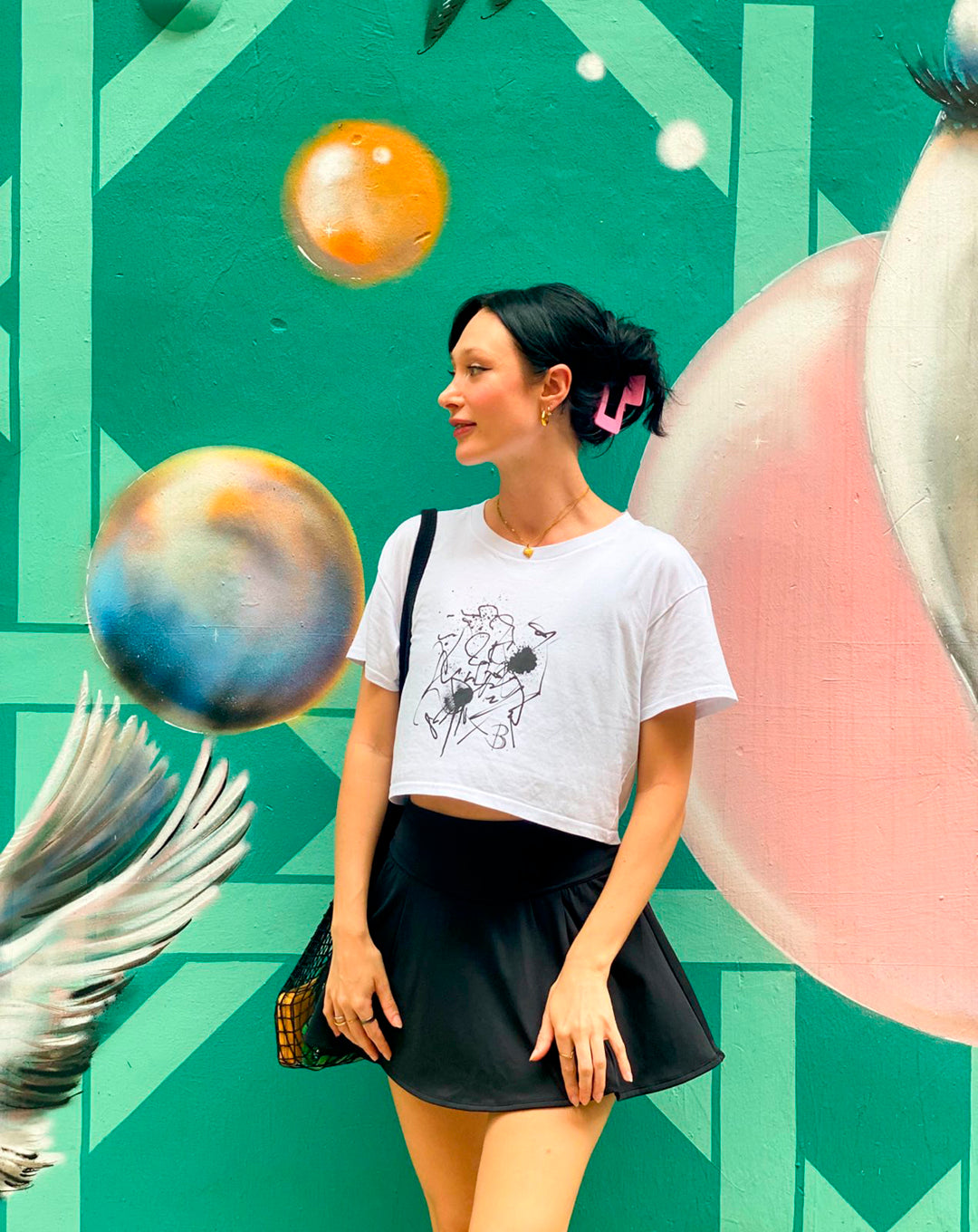 Model, Bridget Standing Wears The Eva Crop Top Tee with black mini skirt. B. Contemporary Streetwear designed by Bridget Bradley