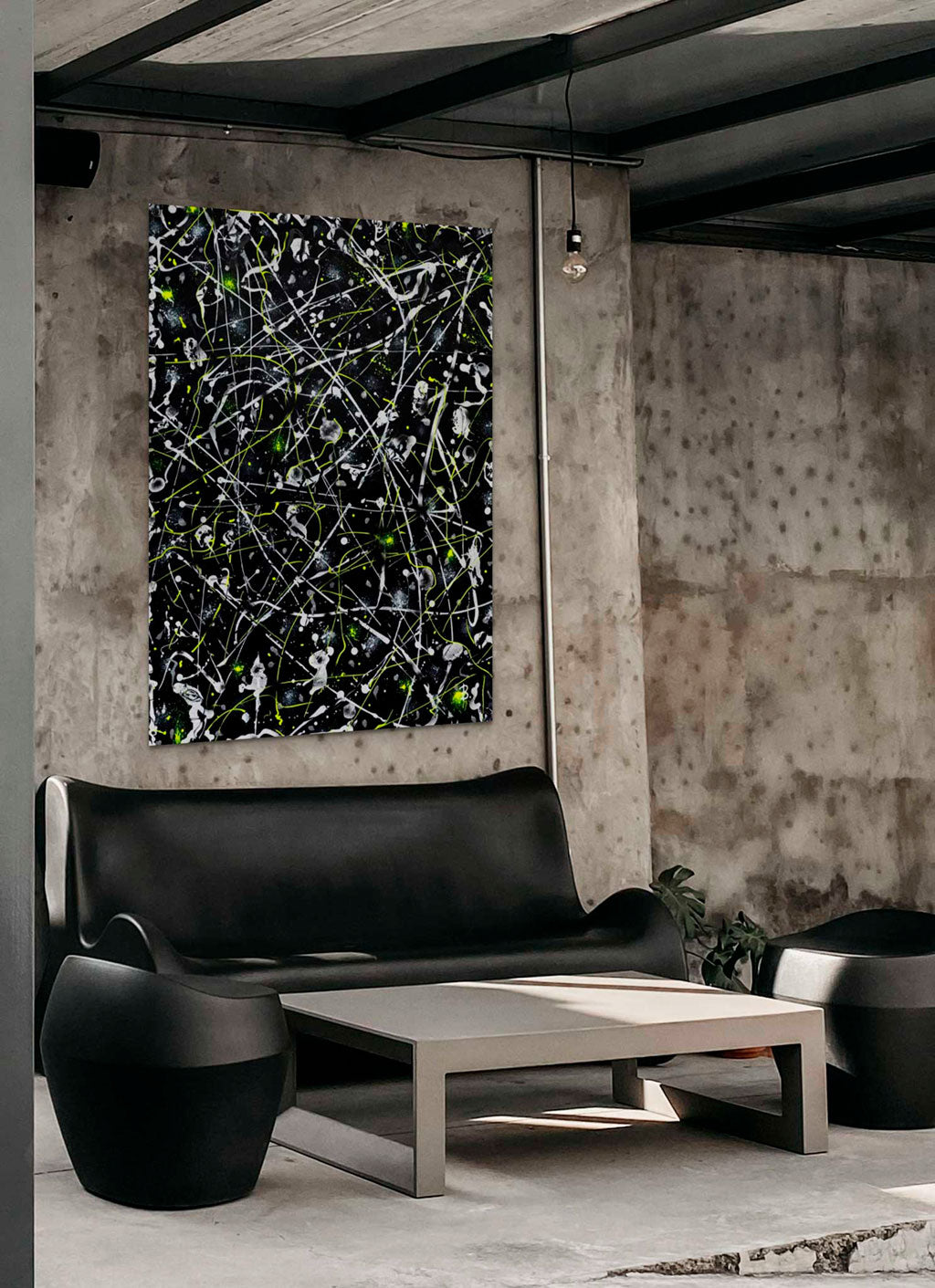 'Space Rock' original abstract painting on canvas with black background, white and neon yellow marks seen hanging above a black sofa. Painting by Bridget Bradley, Abstract Artist, Australia