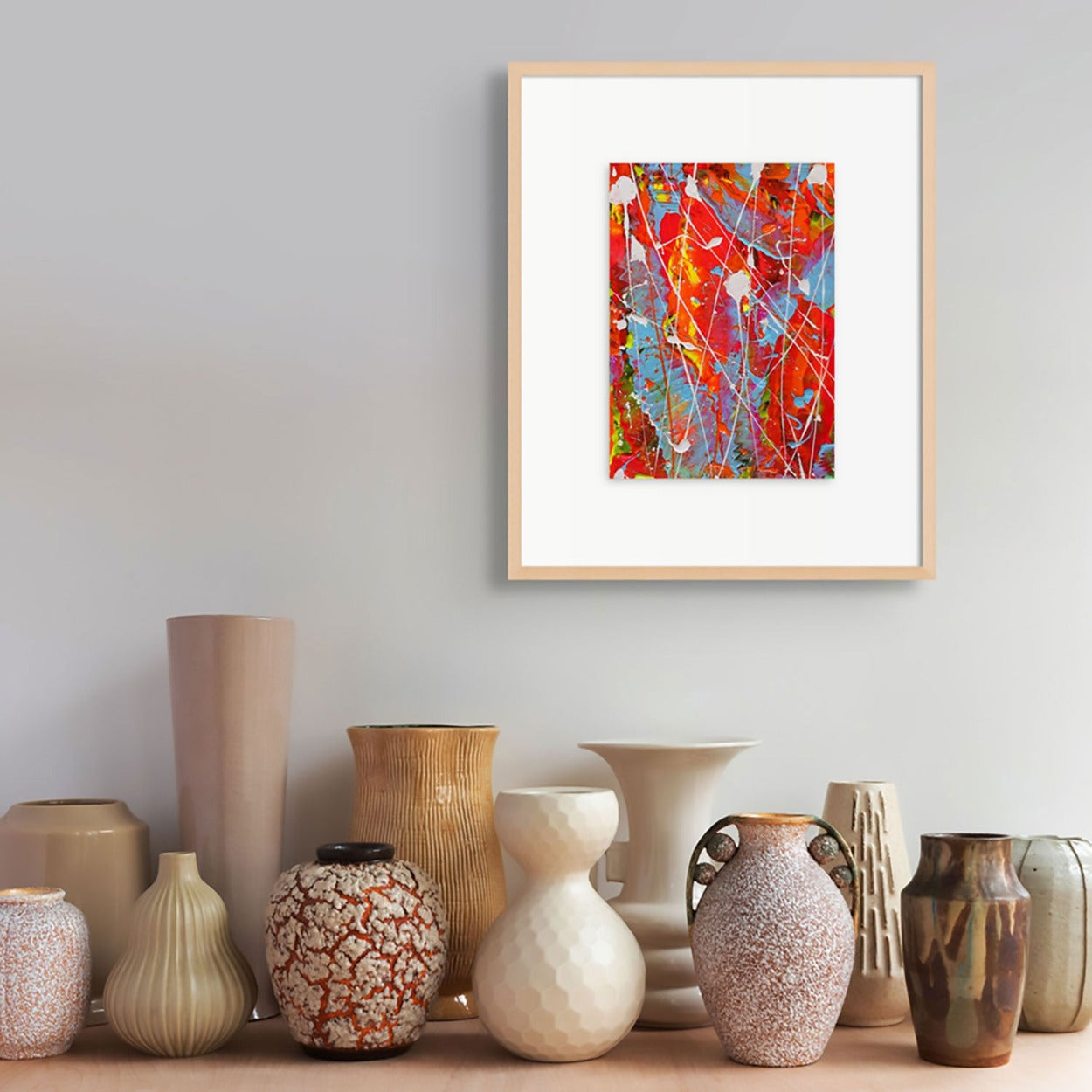 Volcanic, original art on paper by Bridget Bradley, seen hanging on wall above clay pots