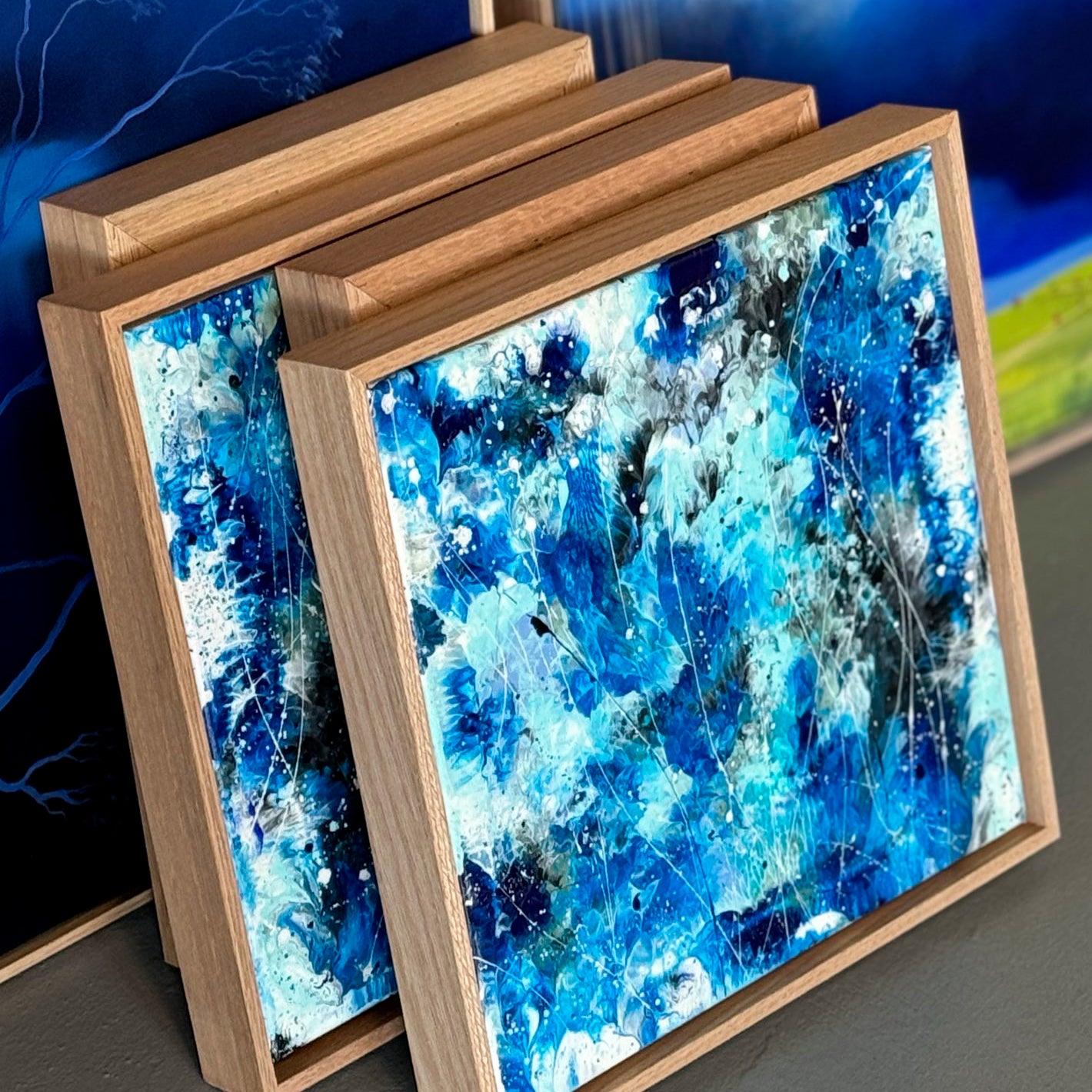 'AZURE WATERS I and AZUREWATERS II abstract expressionism paintings framed in Australian solid wood Tasmanian Oak, leaning on surface in gallery before exhibition. Learn more about these artworks by Bridget Bradley.