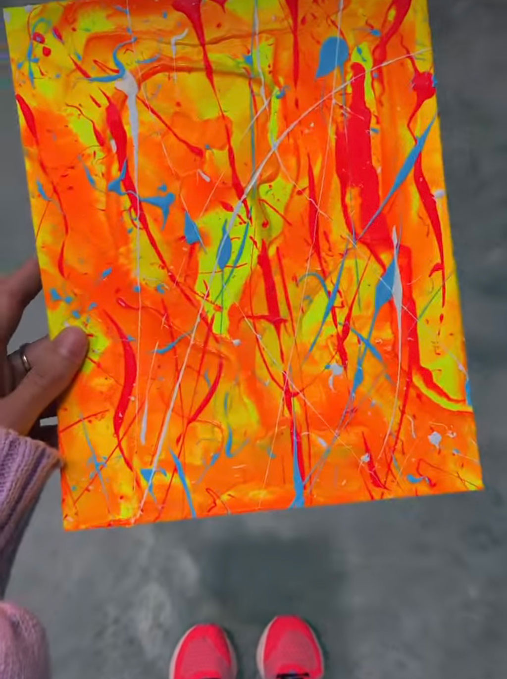 Bridget Bradley, Abstract Artist holds her original painting on paper, 'Fire' a colourful textured abstraction of fire.