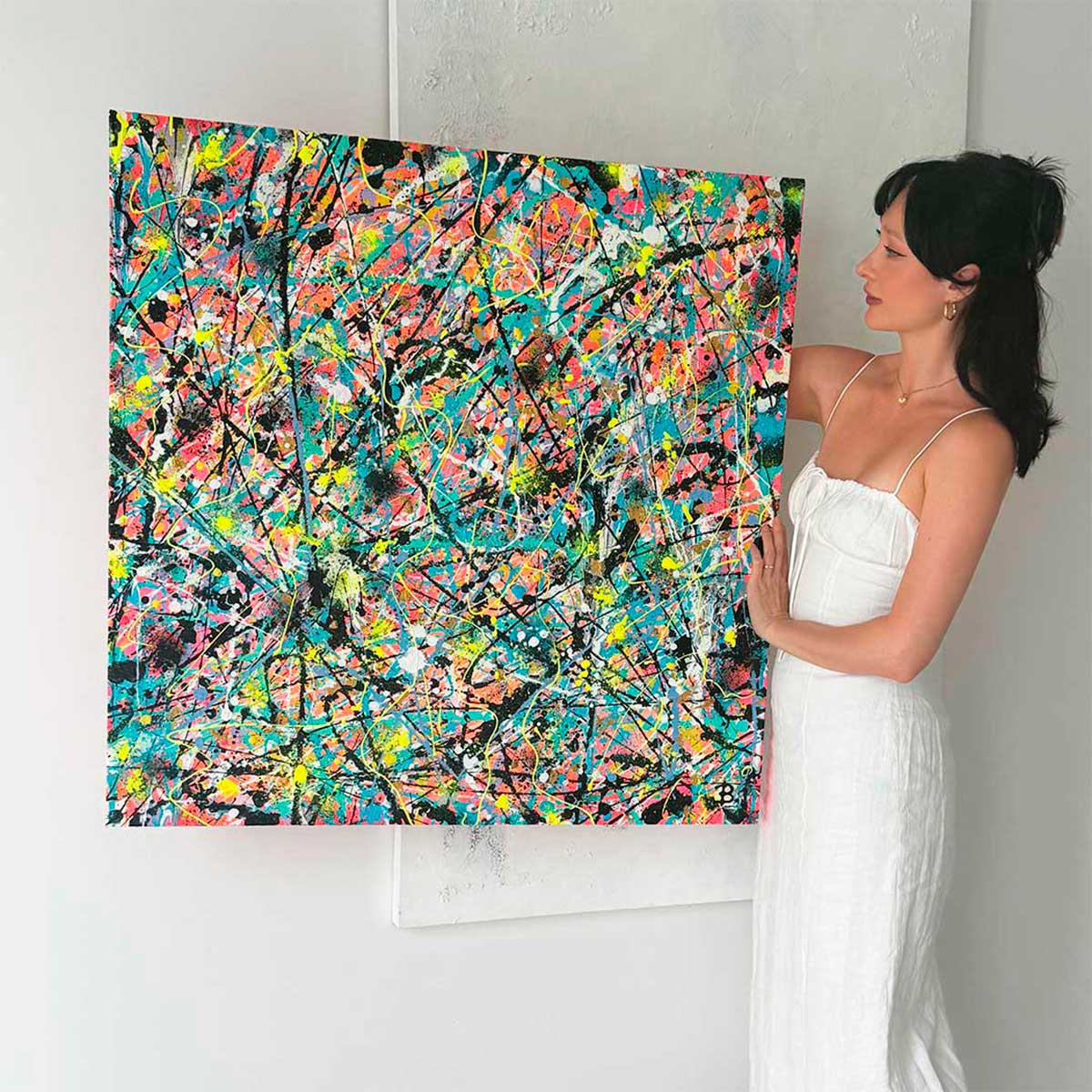 bridget Bradley, Abstract Artist holds her painting 'Labyrinth' . Painted inutitively in 2023. Multiple under paintings and layers with texture and bold  colour including her signature neon highlights