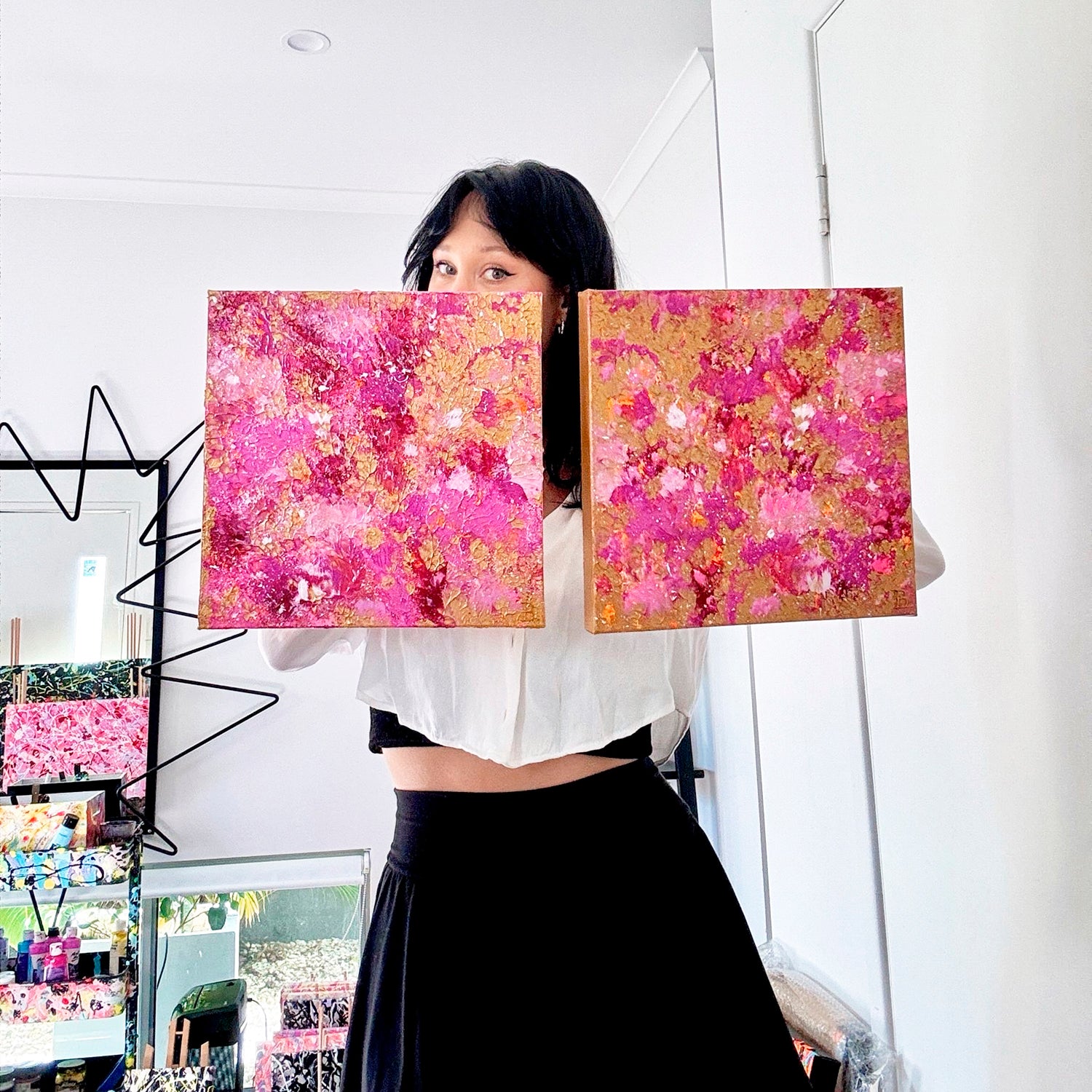 Bridget Bradley, Contemporary Abstract Artist in Studio  Holds Both Golden Hour ! and Golden Hour II original Abstract Paintings in Pinks and Gold Colours