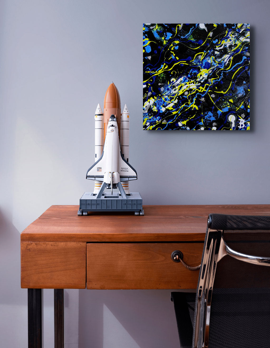 Cosmic, original abstract art by Brigdet Bradley. Brightly coloured and textured, commissioned artwork seen hanging above a desk by rocket model