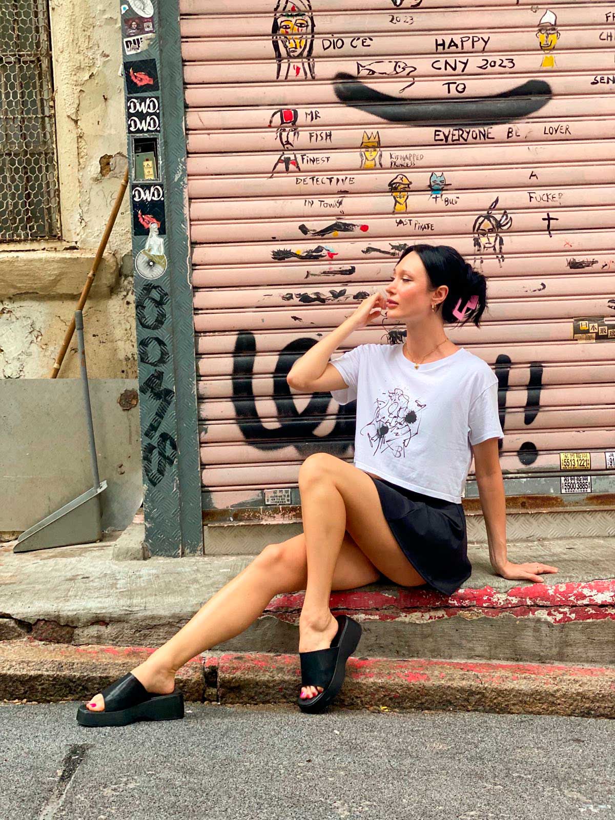 Model Sitting Wears The Eva Crop Top Tee, showing front of tee. B. Contemporary Streetwear designed by Bridget Bradley