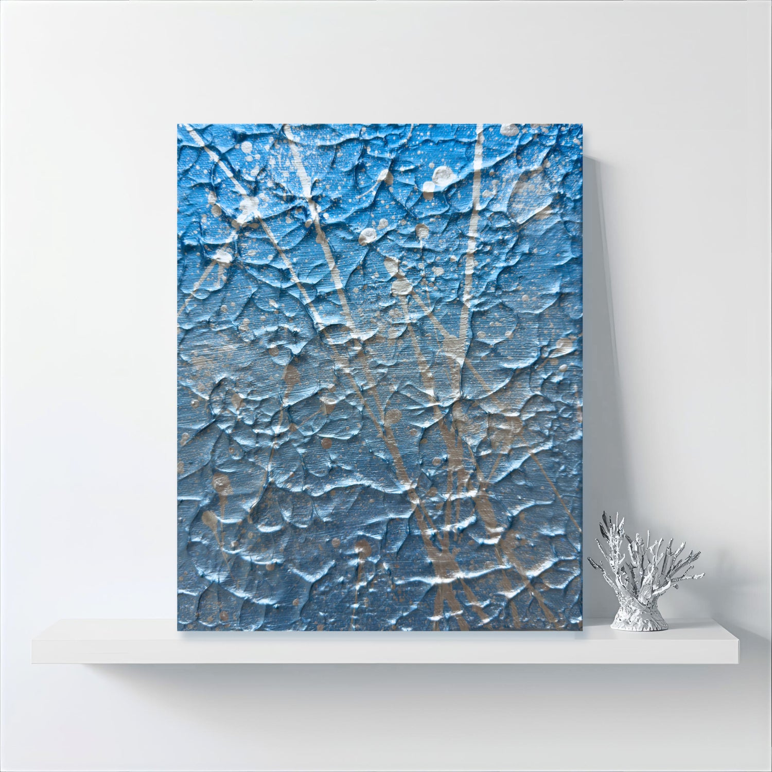 'Ocean Mist' Original Abstract Expressionism Textured Painting with blue and silver hues standing on White Shelf with Silver Coral Ornament at side. Artwork created by Bridget Bradley, Discover now.