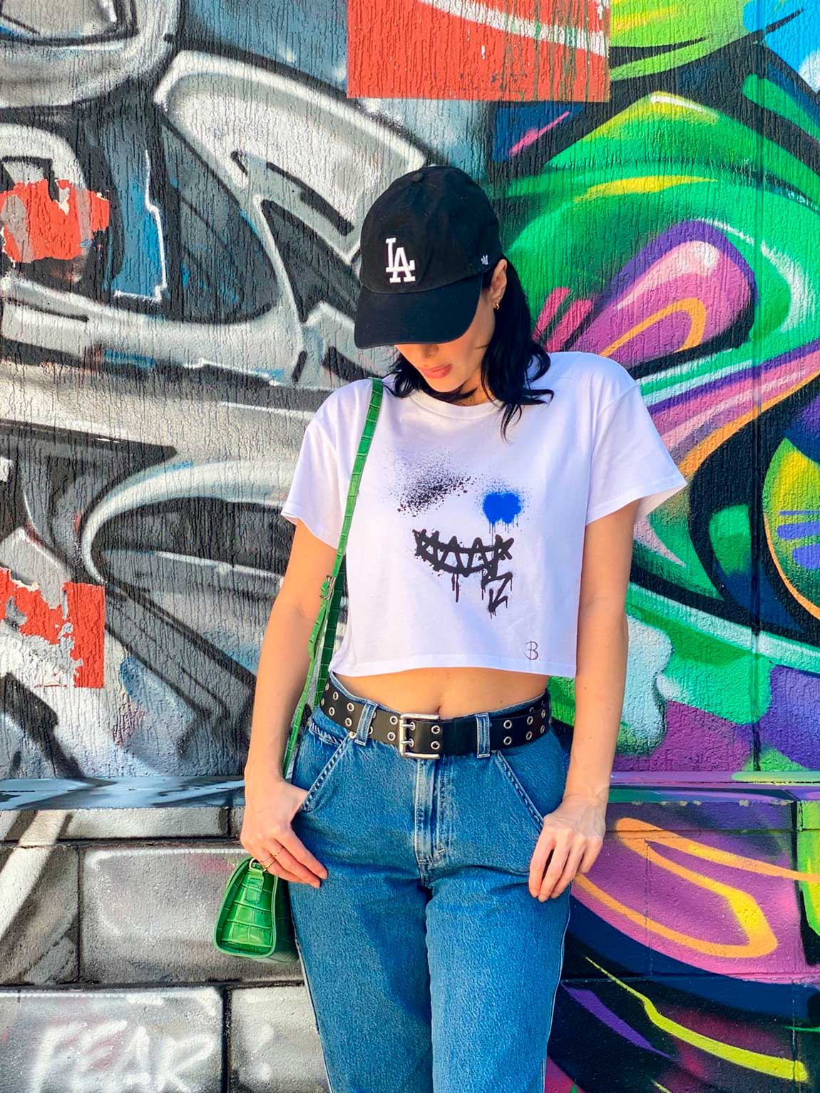 Printed Smile Crop Top Tee Front. Model & Designer Bridget wear her design with blue jeans and black cap. Shop B-Contemporary-Streetwear