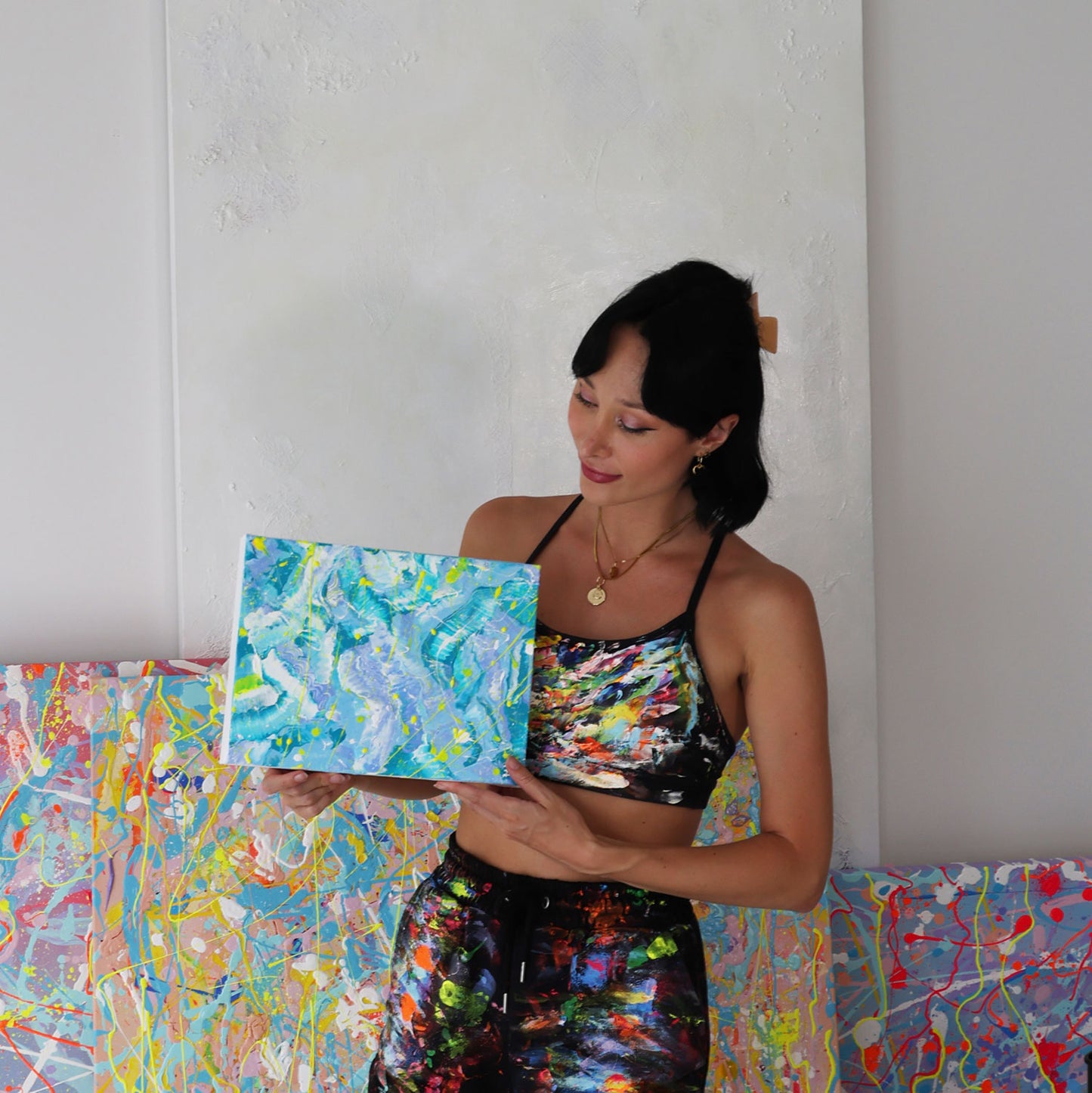 Bridget Bradley, Abstract Artist in painting gear, seen holding her original abstract painting 'Ocean'.