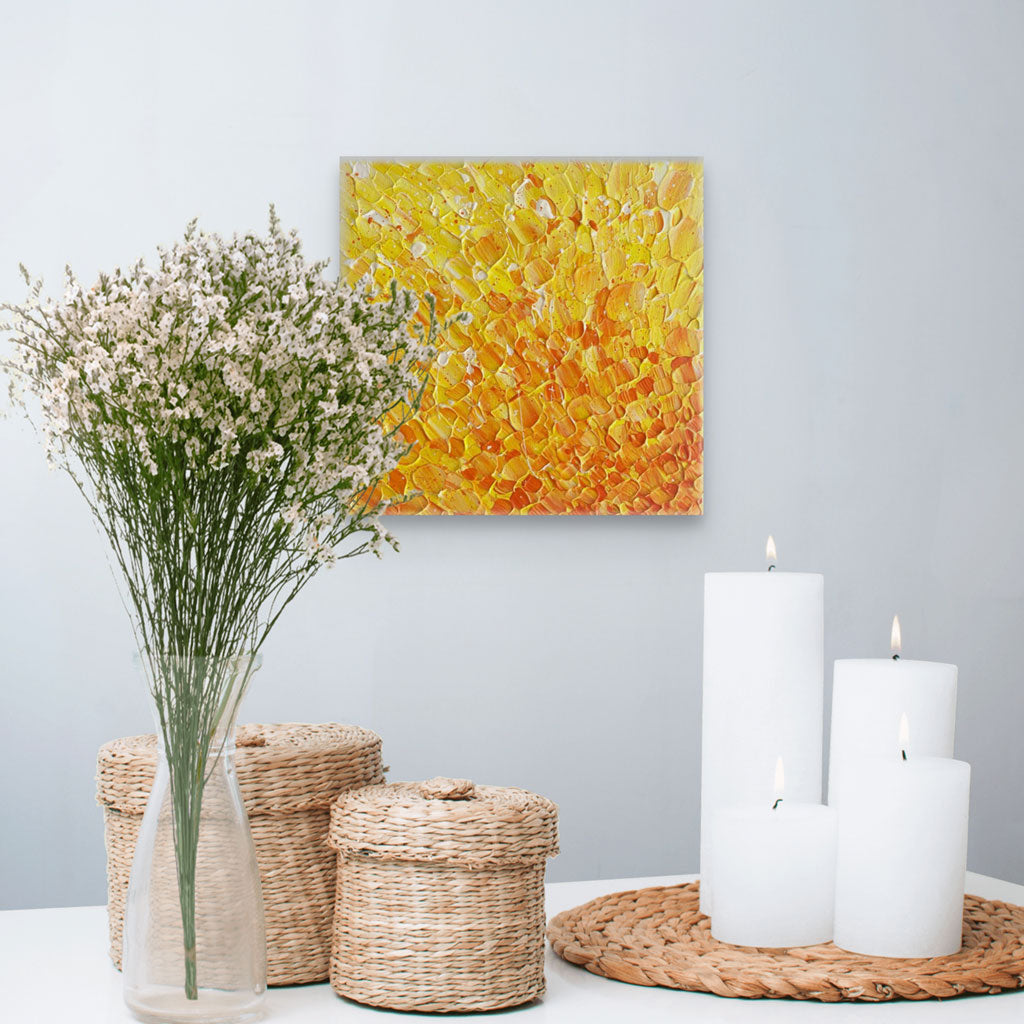 'In the Heart of the Sun' original abstract painting in rich yellows and orange colrs with heavy texture, seen hanging in situ with candles, baskets and vase of wild flowers. Painted by Bridget Bradley, Abstract Artist, Australia