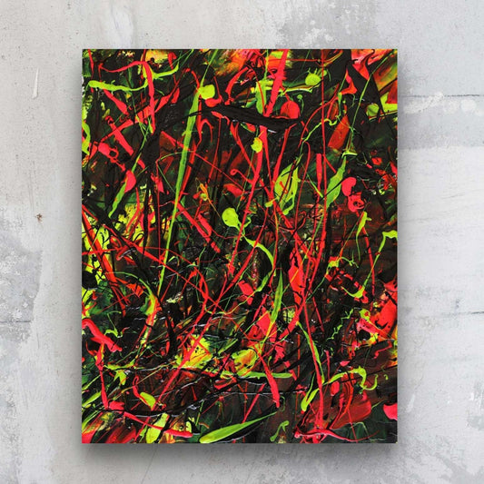 Light Through Dark, original painting on paper by Bridget Bradley. Bold action painting in black, vibrant reds and neon yellows and greens. Seen against stone wall.