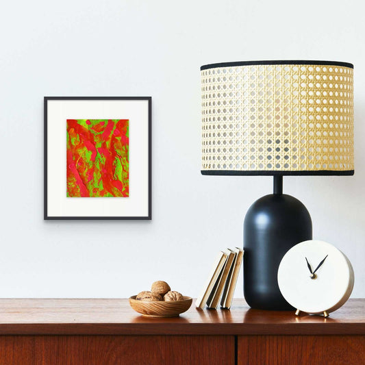 Little Luxuries II, original abstract painting by Brigdet Bradley seen hanging in frame above console with rattan lamp