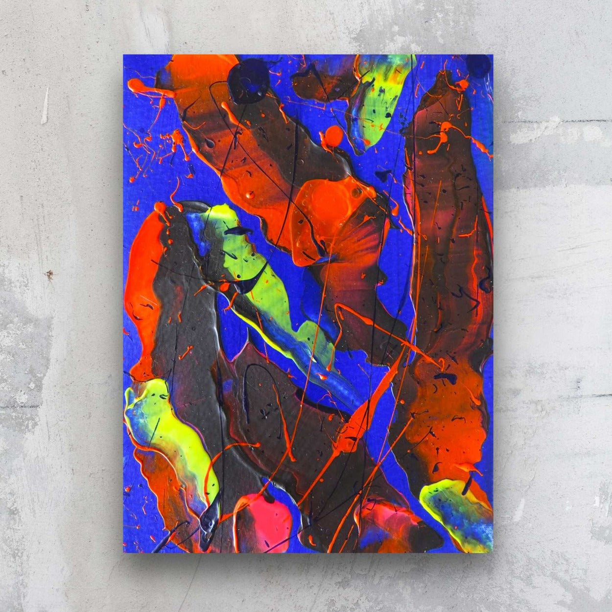 Little Luxuries XI, original abstract art on paper. Bold abstract in reds, electric blue and neons yellow green. Seen hanging on grey stone wall