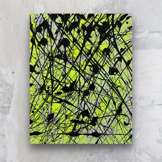 Neon I, original abstract art on paper in neon yellwo and balck, painted by Brigdet Bradley. Seen hanging against a stone wall.