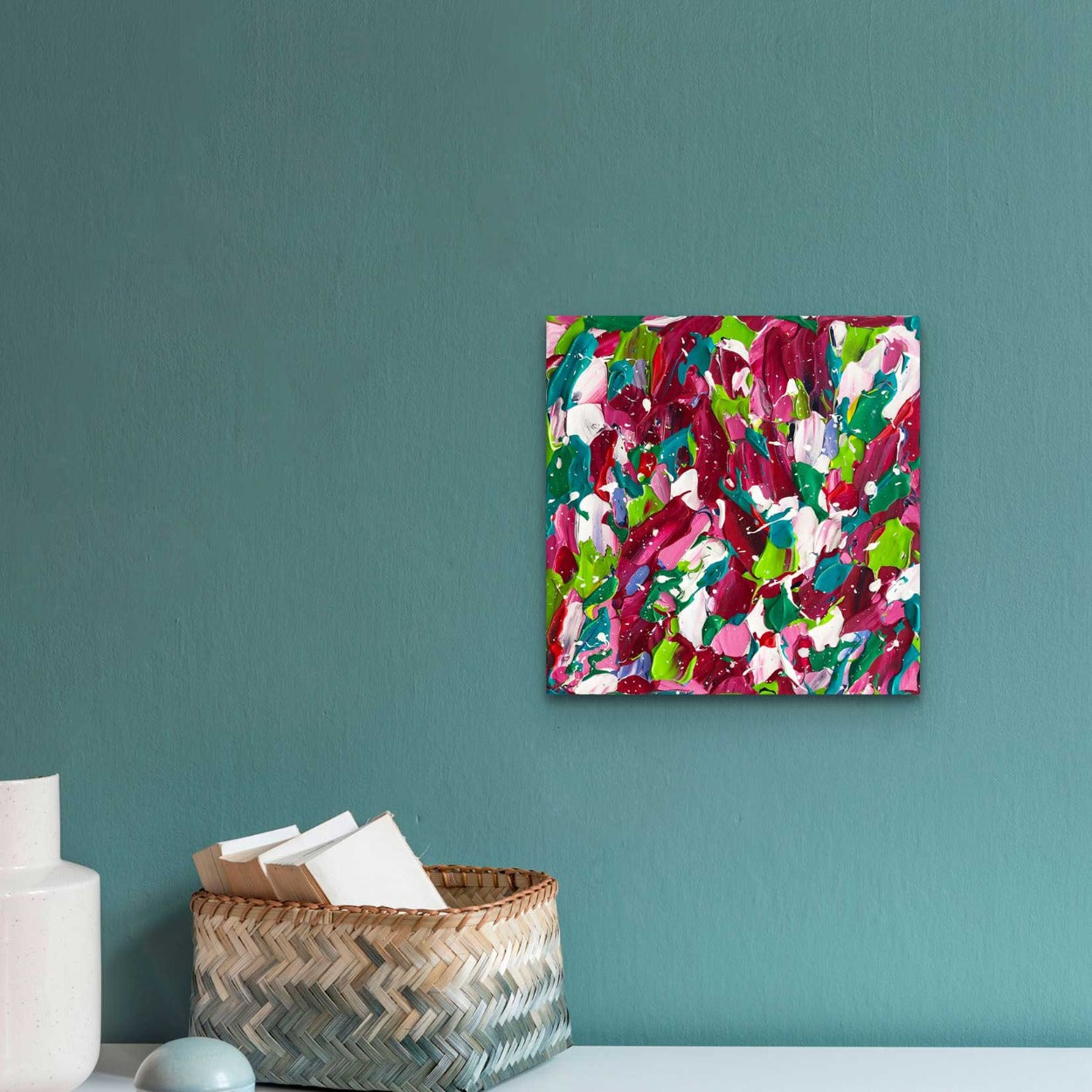 Splash, original textured abstract painting on canvas. Seen hanging in situ against wall with decor. Palette of bold white, greens, reds. Abstract artist, Bridget Bradley