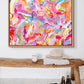 'Sugar Fix' colourful abstract art print on canvas in oak float frame seen ganging above a wooden bench. After the original art by Bridget Bradley