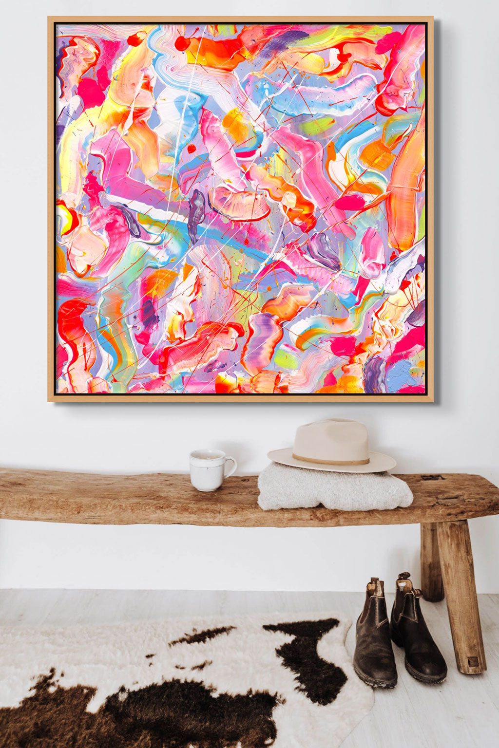'Sugar Fix' colourful abstract art print on canvas in oak float frame seen ganging above a wooden bench. After the original art by Bridget Bradley
