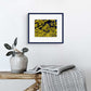 Yellow, original abstract painting by Bridget Bradley seen in navy frame with white mat on wall and silver accessories.